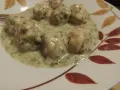 Pyszne klopsiki w sosie koperkowym, podane na talerzu z liśćmi.