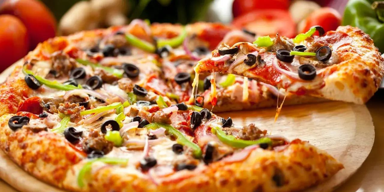 Gotowe ciasto na pizzę z mnóstwem dodatków: pepperoni, oliwki, papryka, cebula i ser. Idealne na wieczór filmowy!