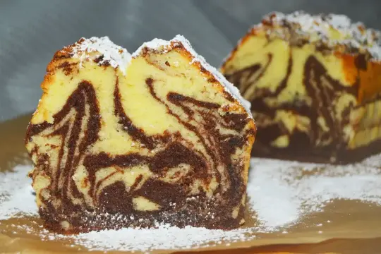 Wilgotna babka marmurkowa na oleju, z pięknymi wzorami czekoladowymi i waniliowymi, posypana cukrem pudrem.