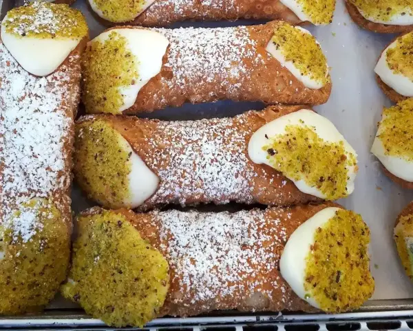 Pyszne cannoli, idealne na deser. Ten przepis na cannoli to gwarancja sukcesu. Posypane cukrem pudrem i pistacjami.