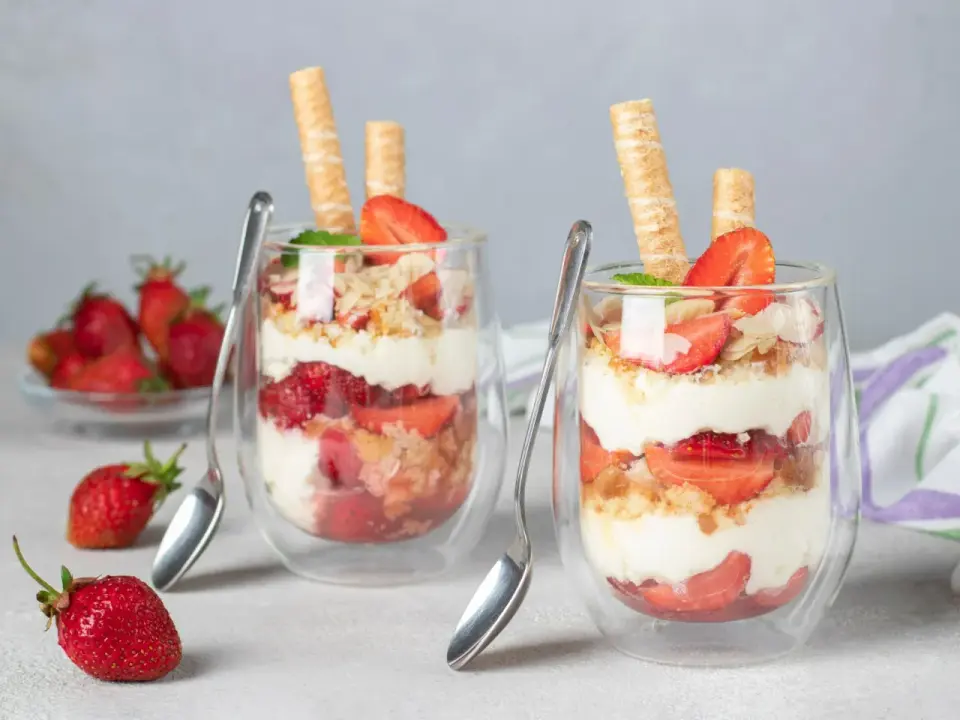 Szybki deser z mascarpone i biszkoptami, przełożony truskawkami, udekorowany wafelkami i miętą. Idealny na letnie popołudnie.